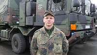 Ein Soldat steht vor Bundeswehrfahrzeugen