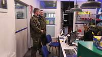 Zwei Soldaten stehen im Verkaufsraum einer Werkstatt.