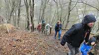 Eine Gruppe Menschen geht bei einer Wanderung einen Anstieg hoch. 