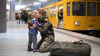 Eine Soldatin umarmt ihr Kind