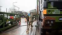 Zwei Soldaten betanken mehrere Bundeswehr-Fahrzeug
