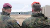 Zwei Soldaten stehen nebeneinander, einer steuert eine Drohne, einer bedient den Störsender.
