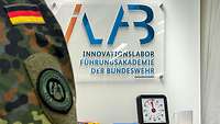 Ein Schild mit der Beschriftung "iLab - Innovationslabor der Bundeswehr" hängt an der Wand.