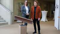 Zwei Frauen stehen in einer Kunstausstellung