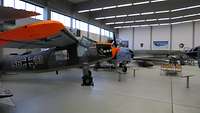 Ehemalige Kampfflugzeuge in einer Ausstellungshalle