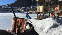 Ein Spielplatz, auf dem Kinder spielen. Die Landschaft ist von Schnee und Eis bedeckt.