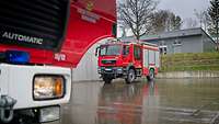 Ein Feuerwehrfahrzeug der Bundeswehr-Feuerwehr auf einer Stellfläche im Regen