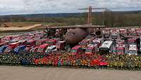 Mehrere Hundert Rettungskräfte und ihre Fahrzeuge beim Gruppenfoto vor einer Flugzeugattrappe