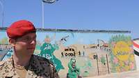 Ein deutscher Offizier steht vor einer Wand, auf der die Aufgabenbereiche der irakischen Pioniertruppe abgebildet sind.
