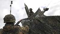 Zwei Soldaten bauen bei Gelber Merkur eine Antenne auf.