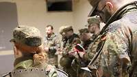 Eine Gruppe Soldaten in einem Bunker macht sich Notizen.