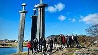 Einige Lehrgangsteilnehmende stehen vor riesigen Schwertern, einem Denkmal in Norwegen