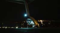 Ein A400M auf einem Landeplatz in Dunkelheit mit geöffneter Laderampe