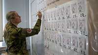 A soldier writing on a large chart.