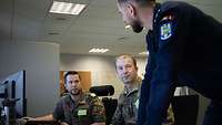 Three soldiers talking to each other.