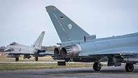 Ein deutscher und ein britischer Eurofighter rollen zur Startbahn der Ämari Air Base