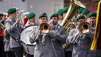 Eine Gruppe von Militärmusikern in grauen Uniformen.