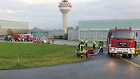 Feuerwehr- und Sanitätsfahrzeuge stehen auf der Start- und Landebahn des Flugplatzes Niederstetten. 