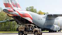 Ein sonderfoliertes militärisches Transportflugzeug und Militärfahrzeug auf dem Rollfeld