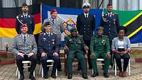 Menschen in Uniform sitzen und stehen für Gruppenbild