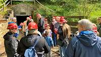 Eine Gruppe Menschen nimmt an einer Führung im Bergwerk unter Tage teil. 