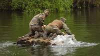 Zwei Soldaten überqueren auf einem kleinen Holzfloß einen See. 