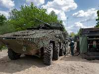 A camouflaged combat vehicle is being refuelled.