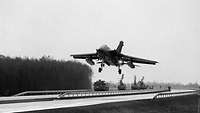 A jet aircraft comes in to land on an autobahn.