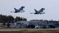 Zwei Eurofighter starten, im Hintergrund ist der Flughafen Rovaniemi zu sehen.