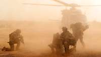 Soldaten sichern die Landung eines Mehrzweckhubschraubers NH-90 in der Wüste