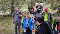 Eine Wandergruppe hört gespannt dem Wanderführer zu.