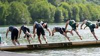 Schwimmende springen in einen Bergsee