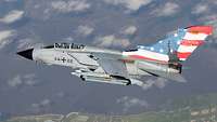 A tornado flies above the clouds. On the fin is Air Defender 2023 on a US flag.