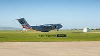 An airplane with USA flag on the rudder during takeoff on an airfield.