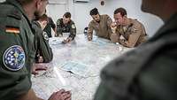 Soldiers at a table with a map on it.