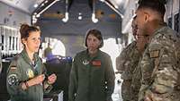 Zwei Fliegerärzte im Laderaum eines Flugzeugs vor US-Soldaten