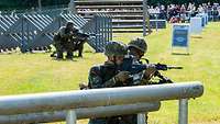 Soldaten in Stellung mit Gewehren bei einer Vorfühung am Tag der Bundeswehr