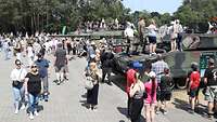 Besucher und Soldaten stehen auf und um Panzer herum am Tag der Bundeswehr