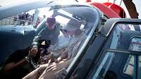 Besucher sitzen in einem Hubschrauber am Tag der Bundeswehr