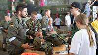 Soldaten erklären Besuchern ihre Ausrüstung am Tag der Bundeswehr