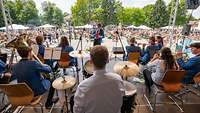 Ein Blasorchester musiziert auf einer Bühne vor Publikum am Tag der Bundeswehr