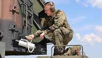 Ein Soldat misst Strahlung am Radar mit dem Strahlenmessgerät.
