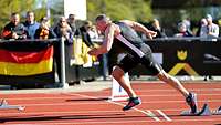 Ein Läufer startet zum Sprint auf der Tartanbahn