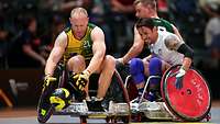 Drei Sportler spielen Rollstuhl-Rugby