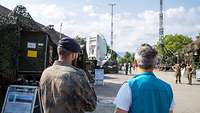 Zwei Männer blicken auf aufgebaute Antennen und Satellitenanlagen.