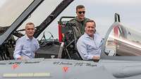 Der NATO-Generalsekretär und der Verteidigungsminister sitzen in einem Eurofighter-Cockpit.