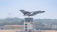 A Tornado fighter jet takes off and flies past the local tower.