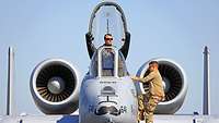 Two soldiers working on an A-10 fighter jet.