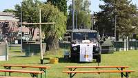 Setting für den Feldgottesdienst mit mobilem Birkenkreuz und dem zum Altar umfunktionierten Wolf