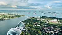 Blick von oben auf den geschäftigen Hafen von Singapur, in den täglich zahlreiche Schiffe einlaufen.